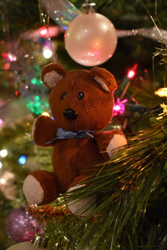 A tiny teddy bear adorns the Christmas tree