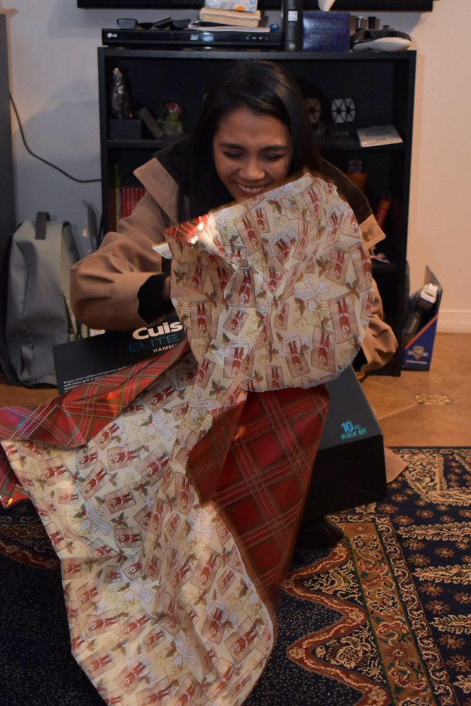 My aunt excitedly opening the first present on Christmas Eve.