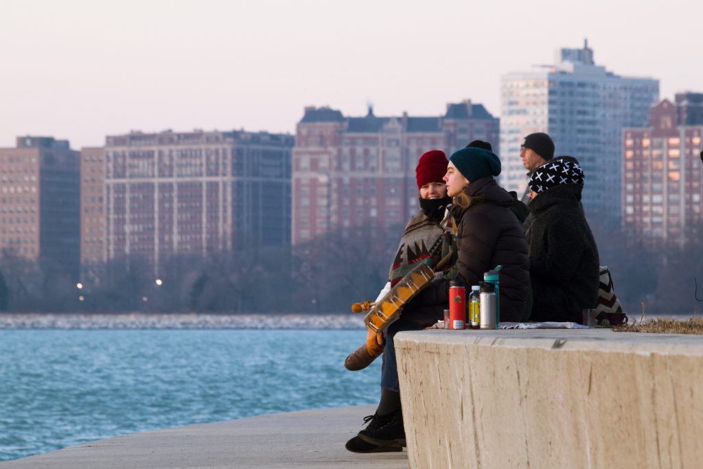 Spectators watching the sunrise at Montrose Beach, Chicago, Illinois.