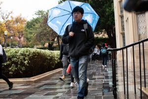 Student uses a blue sky umbrella on a cloudy day. Photo by Tess Horowitz
