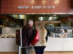 A couple standing in front of a ramen stand