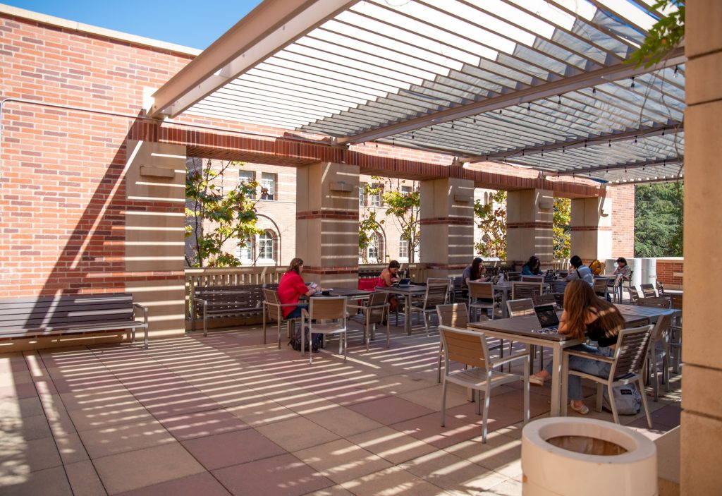 Students study on the Physics and Astronomy Building patio, located on the east end of the third floor past a small kitchenette. Filled with red tanbark in the center and furnished with tables to the north, students can usually find seats open in the shade. Photographed by Julia Gu/BruinLife.