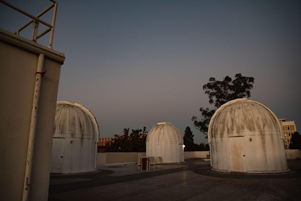 The elevator to the ninth floor of the Mathematical Sciences Building opens directly to the three telescopes on the eastern roof. If students know where to look, they might catch a glimpse of the three white domes from the court below. Photographed by Julia Gu/BruinLife.