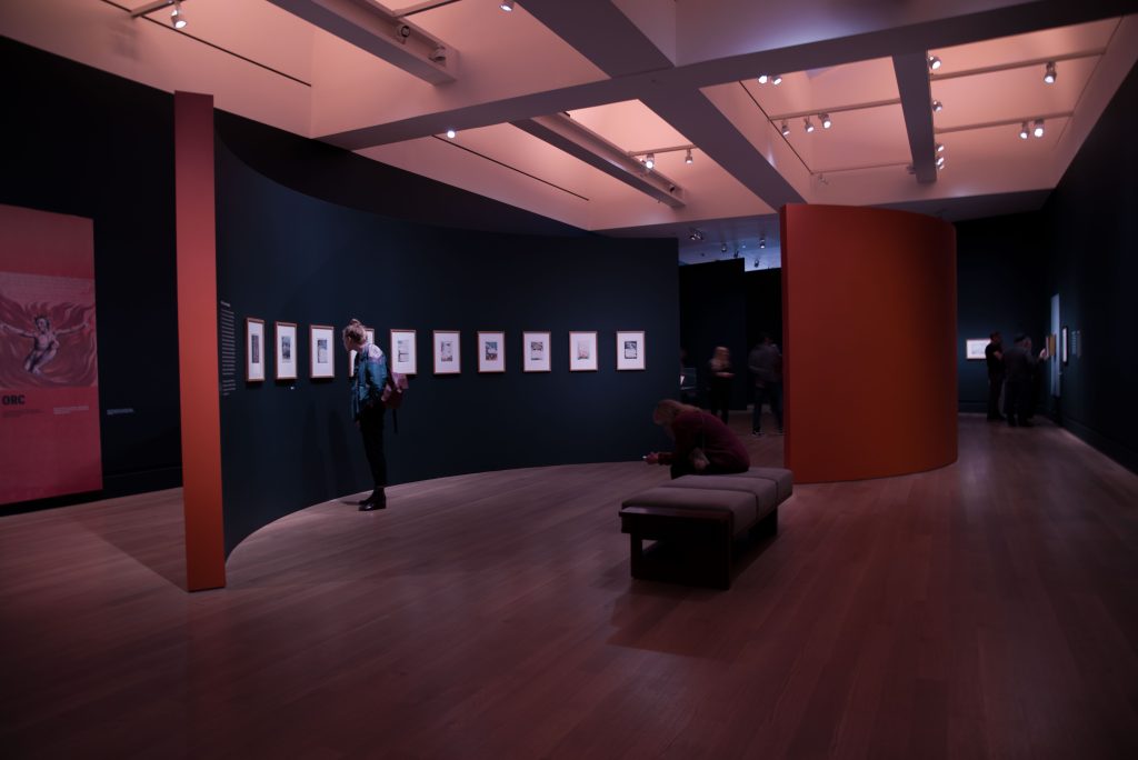 A visitor examines some of William Blake's artwork. Photo by Katelyn Michel/BruinLife.