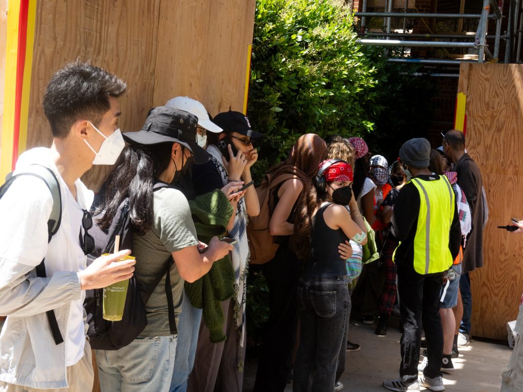 Students line up by a check-in point for the pro-Palestine encampment. Calls for a medic were overheard nearby. Photographed by Finn Martin/BruinLife.