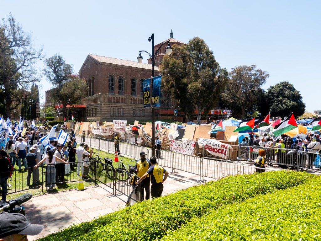 From 11 a.m. to 1 p.m. on April 28, pro-Israel protesters occupied the Dickson Plaza lawn neighboring the pro-Palestine encampment. Campus security forces manned passageways between the two groups. Photographed by Finn Martin/BruinLife.