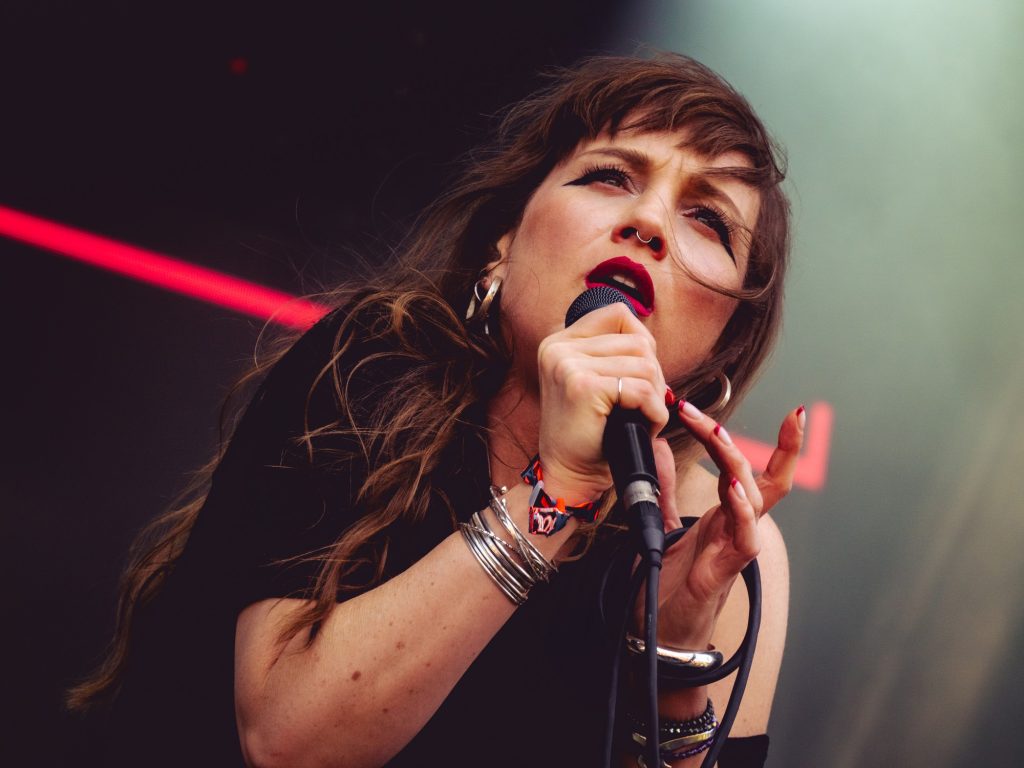 Vocalist Chelsey Crowley of Nuovo Testamento pauses her dance routine for a moment to clutch the microphone and glance out over the Sad Girls stage. Photographed by Finn Martin/BruinLife