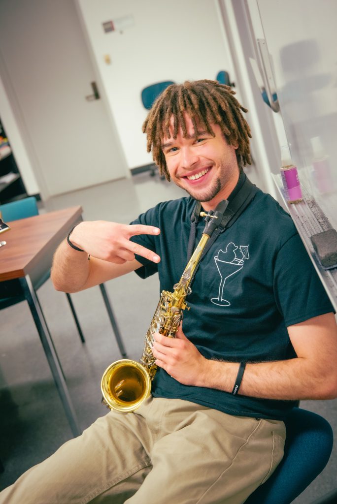 Stafford Williams, a third year neuroscience major and saxophonist, takes a pause between beats to greet the camera. Photographed by BruinLife/Finn Martin