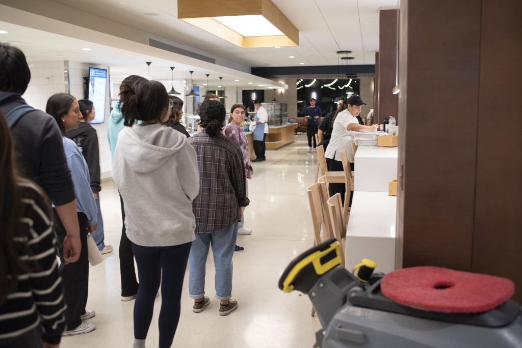Bruin Dine volunteers catch up as a worker for Epicuria at Covel labels surplus food from the dinner meal period. Dining halls develop a relationship with Bruin Dine as they go about their rounds collecting food for distribution. Photographed by Julia Gu/BruinLife