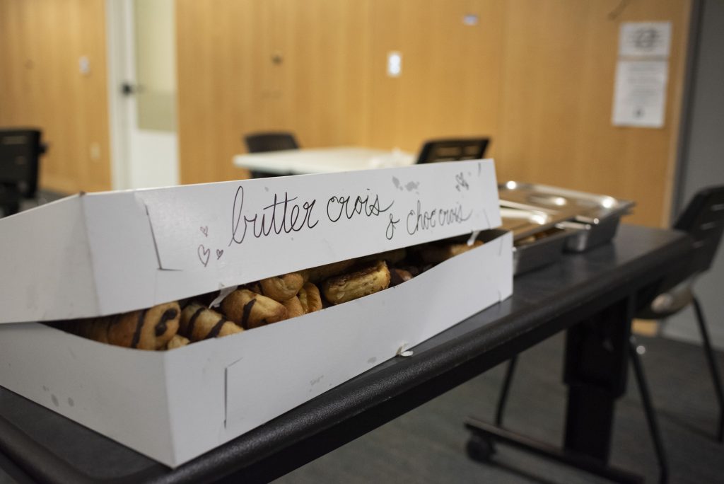 A lovingly decorated box sits on a table, filled with buttery, jam-filled, and chocolate-drizzled pastries. In addition to collecting food from the dining halls on the Hill, Bruin Dine works with Kerckhoff Coffee House to recover additional goods for the day. Photographed by Julia Gu/BruinLife