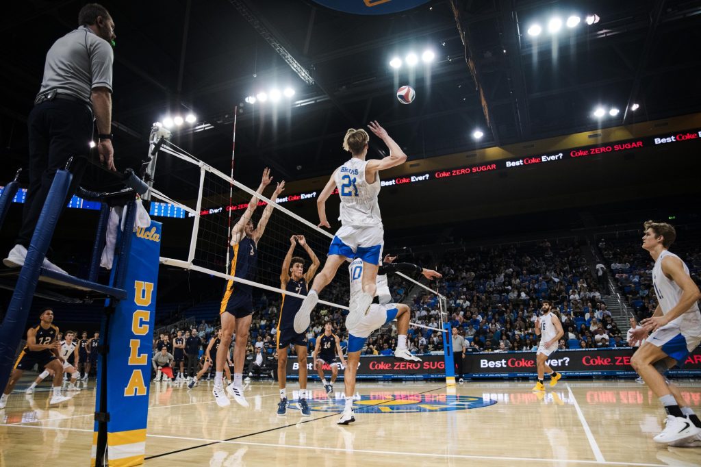 UCLA's #10 Sean McQuiggan sets the ball to #21 Zach Rama, who positions himself to unleash a powerful spike. Photographed by Ryan Zhang/BruinLife