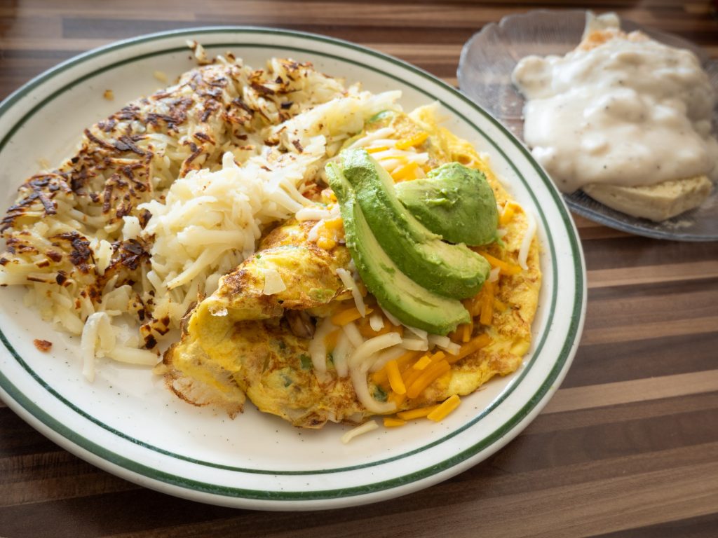 The veggie omelet balances the green freshness of avocados, mushrooms, tomatoes, onions and bell pepper with the heavier breakfast classics, hash browns and biscuits and gravy. Photographed by Finn Martin/BruinLife