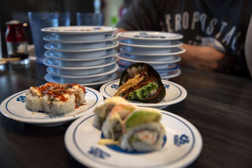 Plates stacked up high with a couple of dishes ready to be eaten in the foreground. Photographed by Emily Chandler/BruinLife.