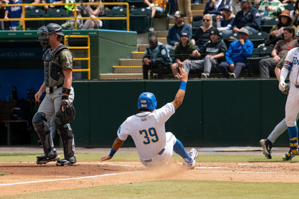 #39 Mulivai Levu, slides into home plate, scoring a run against Penn State. Photographed by Maia Salti/BruinLife