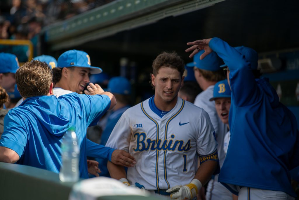 Infielder #1, Roch Cholowsky, returns to the dugout after blasting a home run, greeted by his teammates with cheers and pats on the back. Photographed By Maia Salti/BruinLife