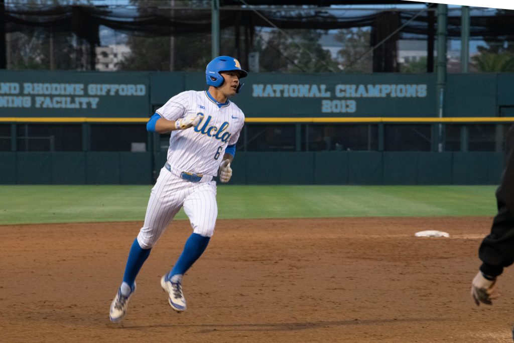 UCLA players runs from second base to third.