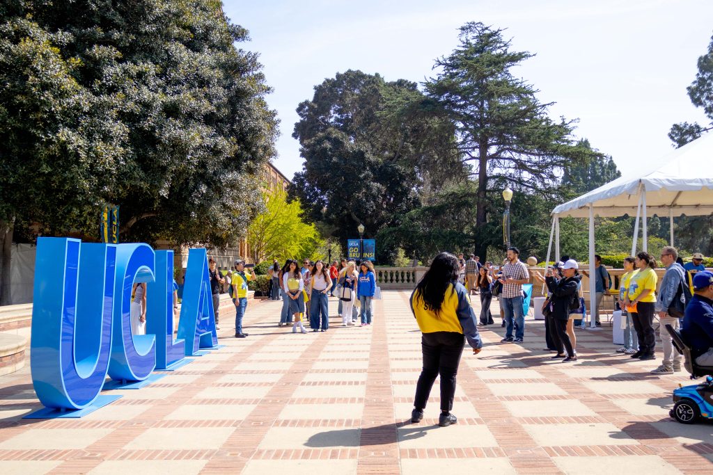 Prospective students pose for photos by giant UCLA letters at the top of Tongva Steps. Placed on the backdrop of Royce Hall, Powell Library, and the grassy fields of Dickson Court, Bruin Day is filled with opportunities to interact with UCLA's campus, students, and alumni. Photographed by Julia Gu/BruinLife.