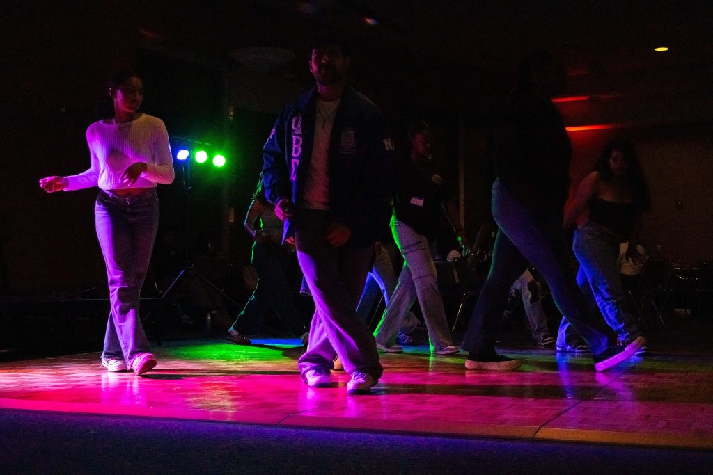 Students step onto the illuminated floor to line dance. With no lights but disco lights, the annual Blackout event never fails to bring students together through music and dance. Photographed by Julia Gu/BruinLife.