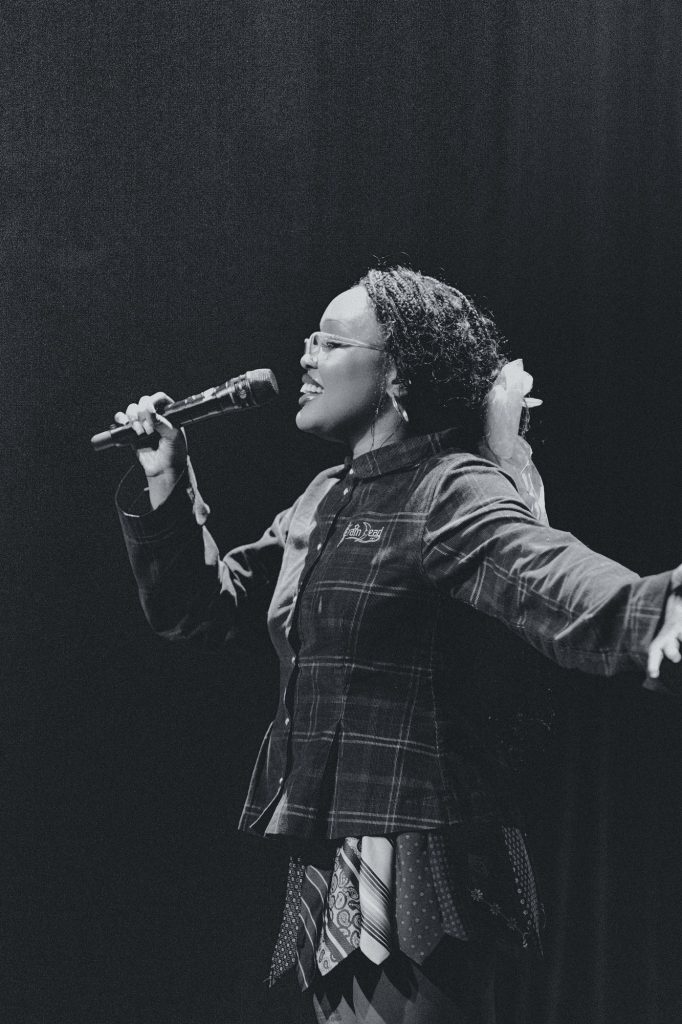 Amindi opens her arm as she sings out to the crowd. Photographed by Amy Miranda/BruinLife