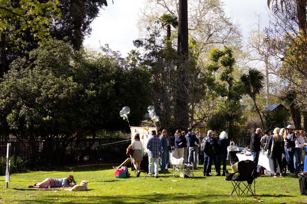 A group gathers for a special occasion as picnickers lounge nearby. Photographed by Julia Gu/BruinLife.
