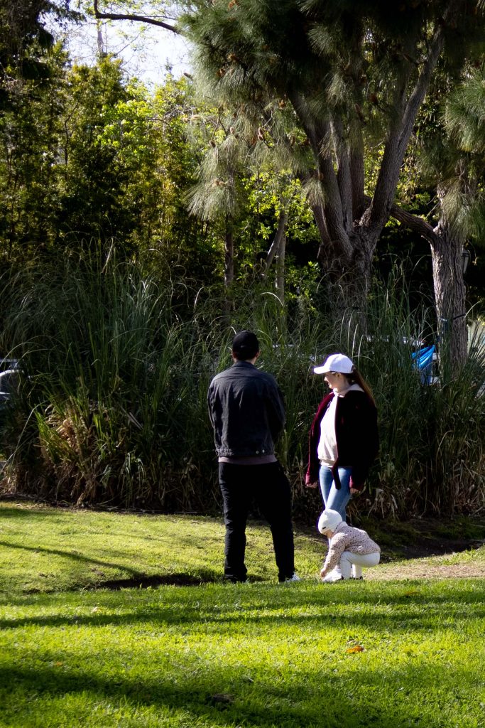 A family enjoys the greenery – the parents visually, the child physically. Photographed by Julia Gu/BruinLife.