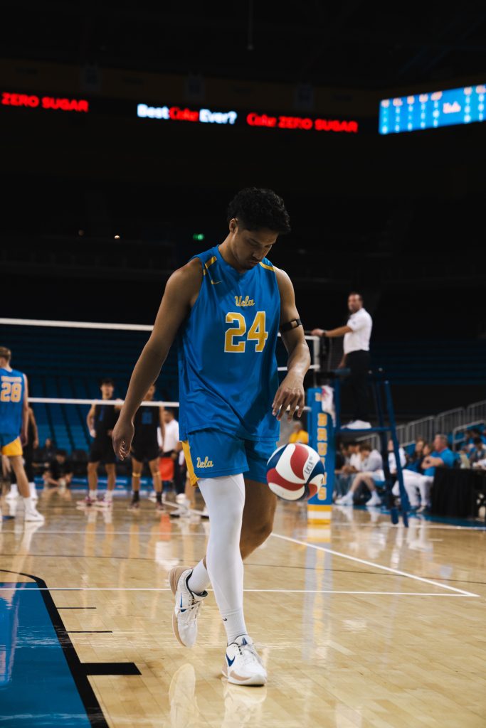 Sophomore Kahale Clini makes his way to the back of the court to serve for UCLA. Photographed by Cathryn Kuczynski/Bruinlife.
