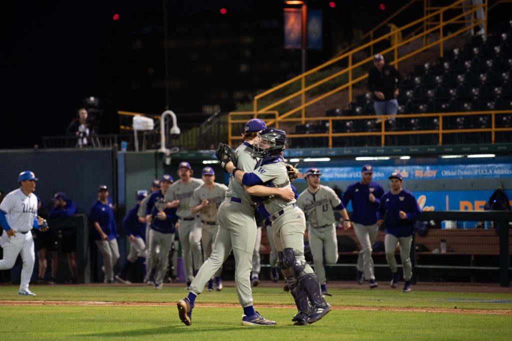 Washington's closing pitcher and catcher celebrate with a hug after the game's final strikeout.