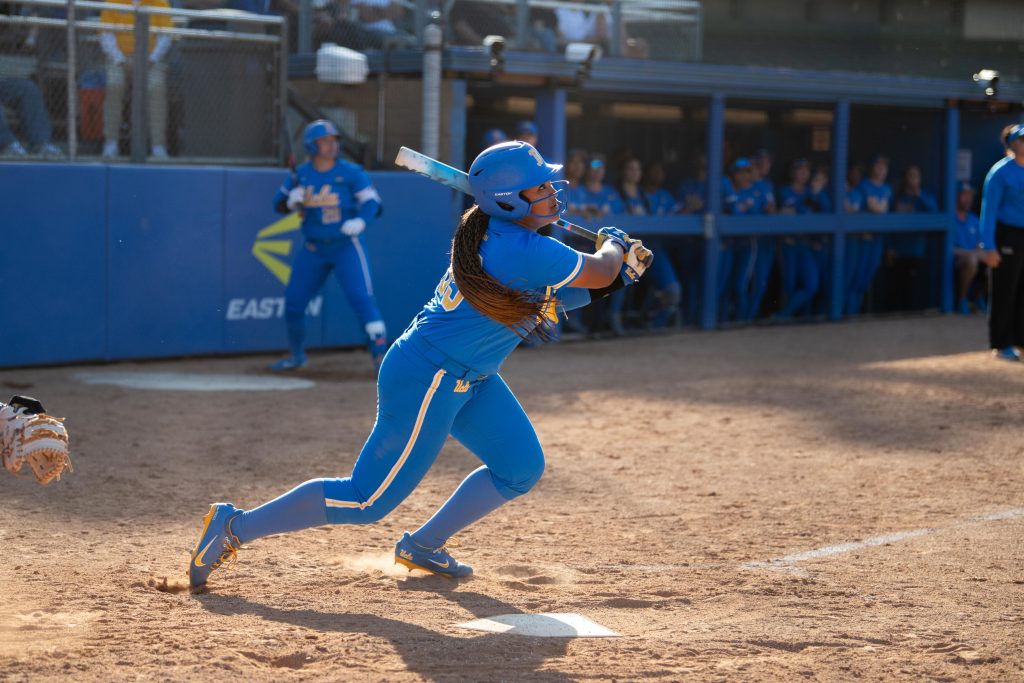 Infielder Kaniya Bragg looks up after making contact with the ball, preparing her sprint to first base. Photographed by Maia Salti/BruinLife