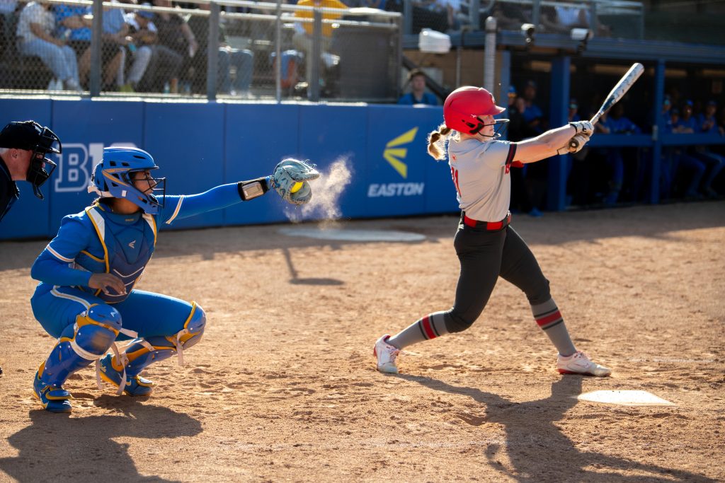 Freshman catcher Maggie Daniel secures the ball after a swinging strike. Photographed by Maia Salti/BruinLife