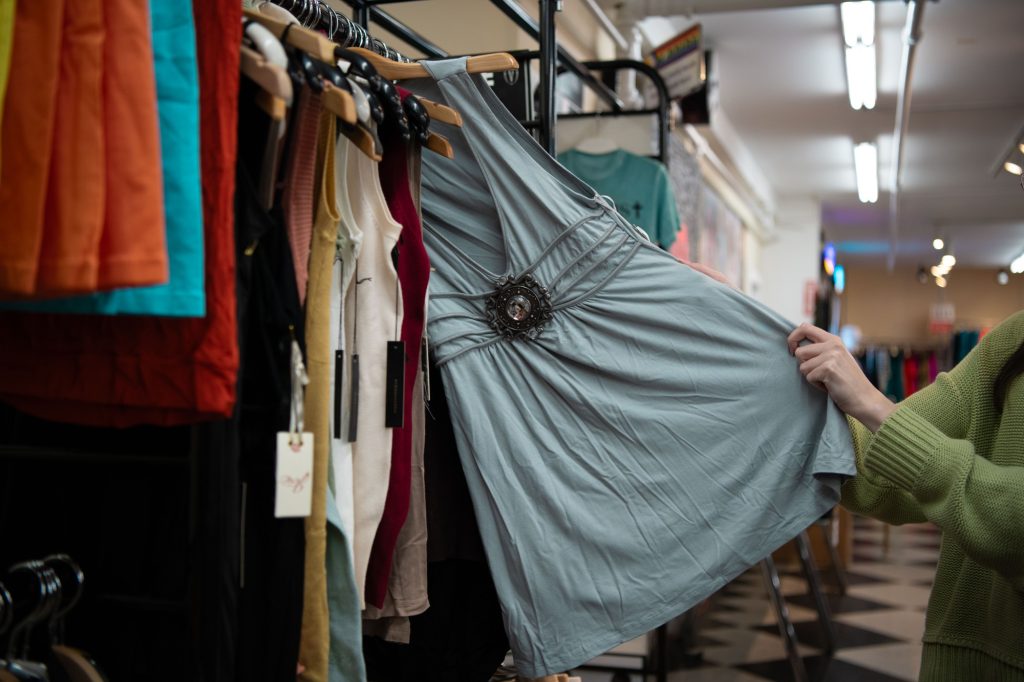 Person grabs for turquoise shirt with commonly seen Y2K emblem in the middle.