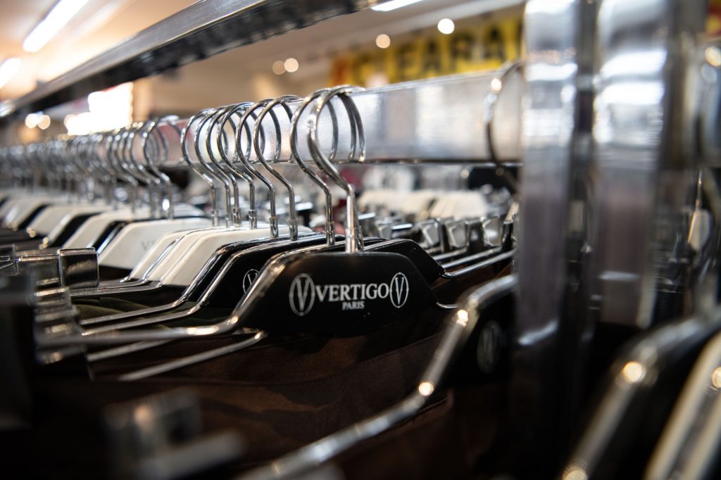 Hangars labeled with supplying brand "Vertigo", seen throughout the store.