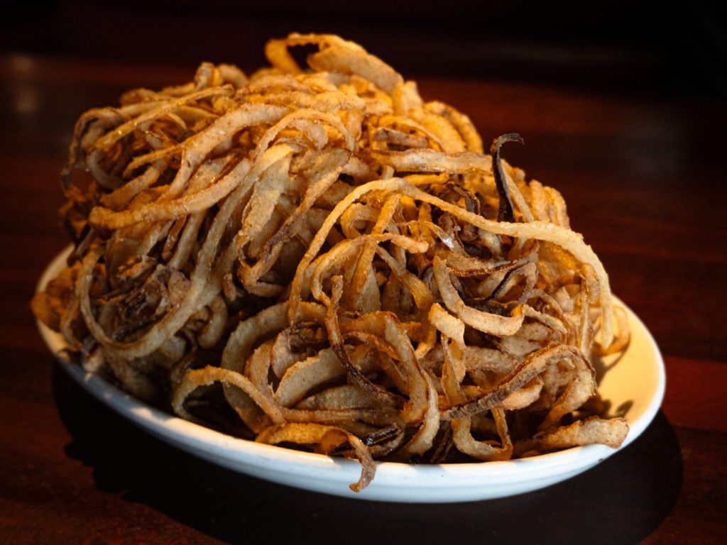 Shredded, crisped and delicately salted, the Famous Shredded Onions kick start the meal with an easy going appetizer that is best eaten by hand. Match it with the house barbecue sauce to unlock a whole new combination of flavor. Photo by Finn Martin/BruinLife.