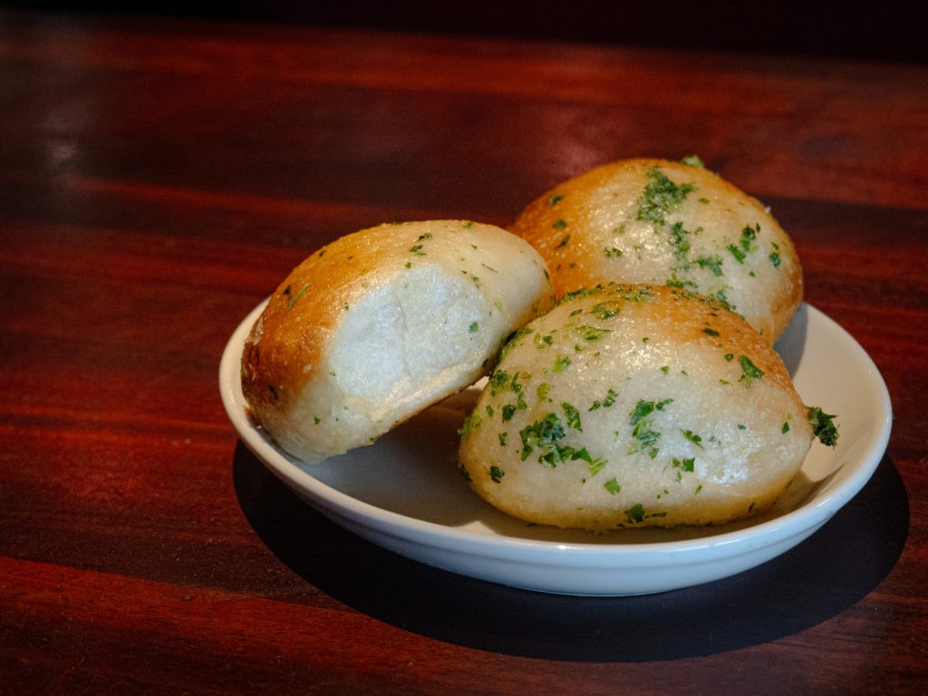 Good things come in three -- and the garlic bread is no exception. Puffy on the inside, hard shell on the out, these appetizers also went well with the house BBQ sauce. Photo by Finn Martin/BruinLife.