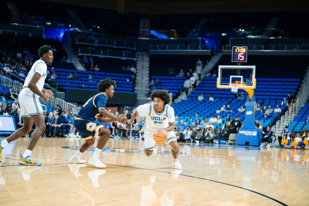 #55 Skyy Clark attacks the lane, weaving past multiple Anteater defenders in transition during UCLA's commanding performance against UC Irvine. Photographed by Ryan Zhang/BruinLife.