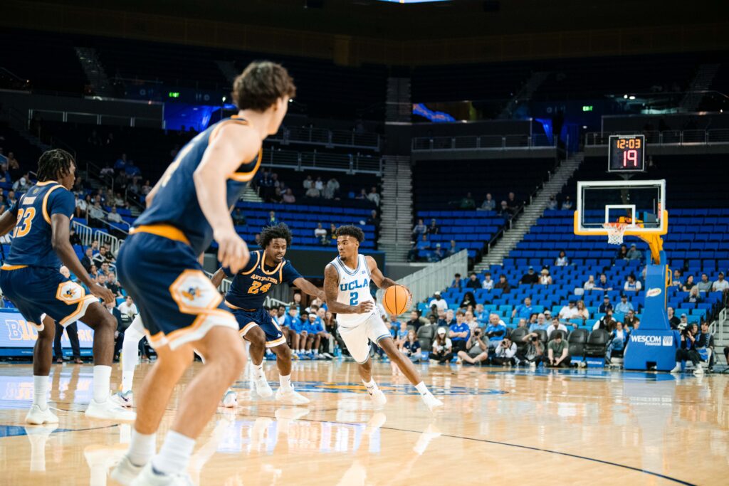 #2 Donovan Dent surveys the floor and reads the UCI defense, orchestrating the Bruin offense with poise and vision. Photographed by Ryan Zhang/BruinLife.