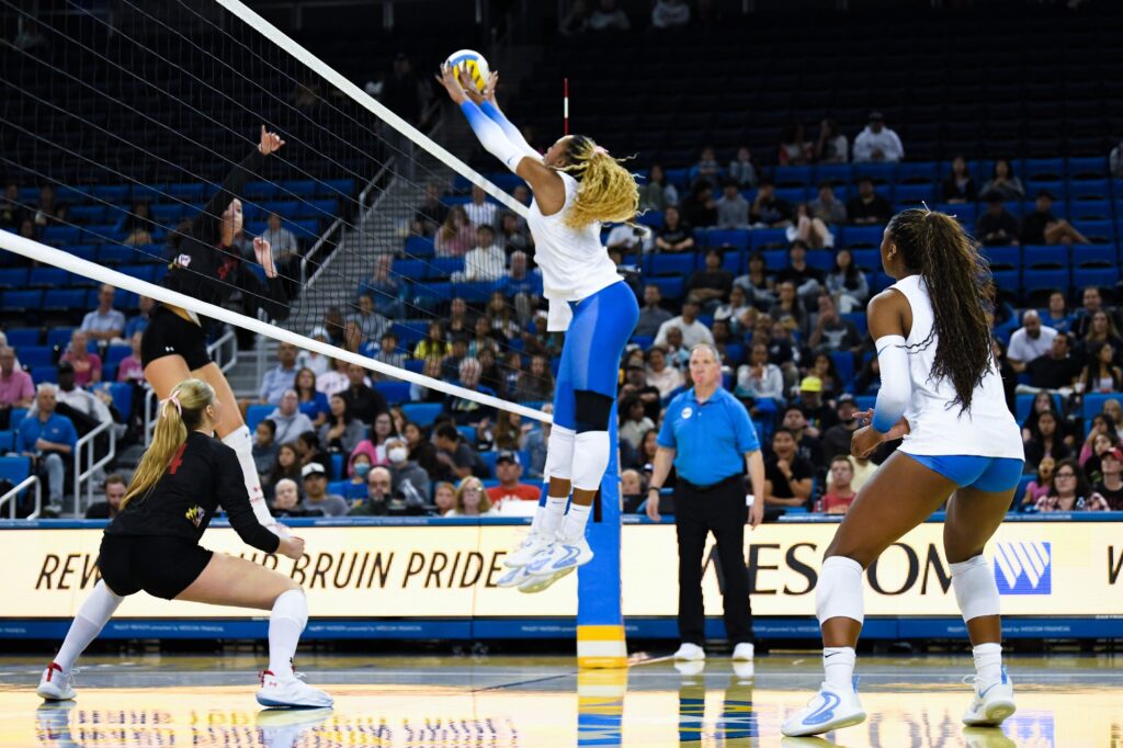 UCLA's number 11, Marianna Singletary jumps to block ball against Maryland's outside hitter, gaining a point for UCLA. Photo by Luana Caravalho