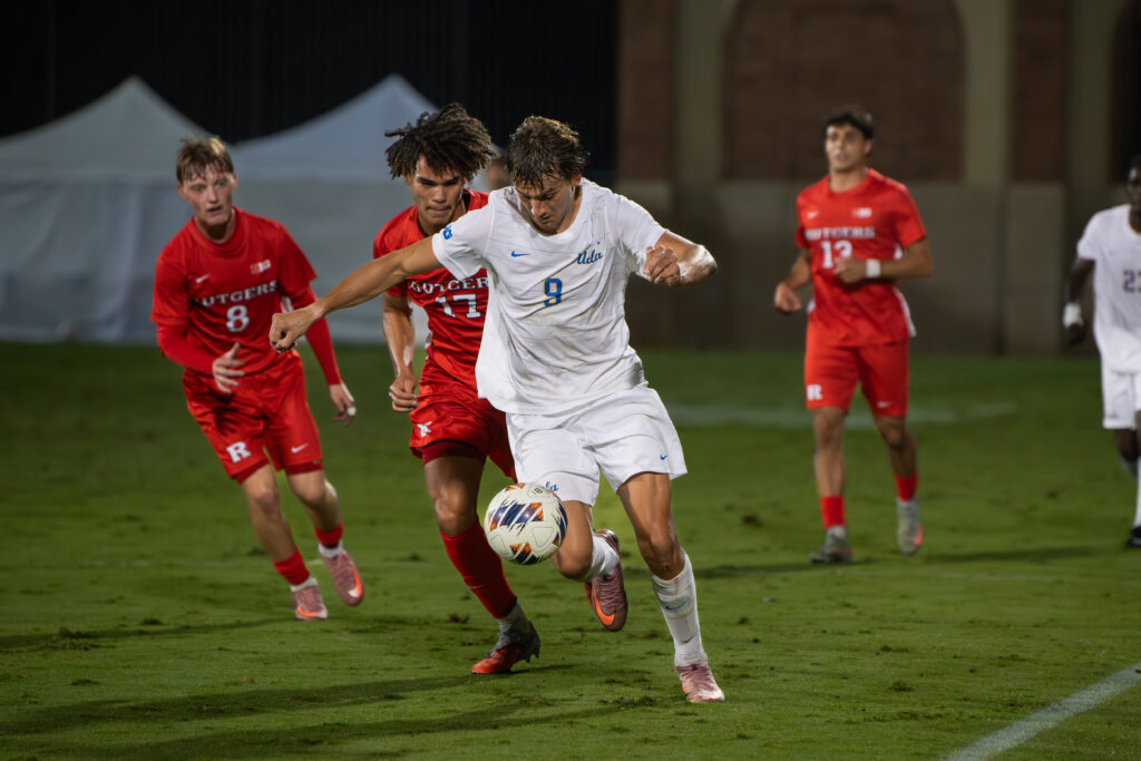 Forward Sergi Solans Ormo (player #9) steals the ball from Rutger's midfielders as he braces to score yet another goal, creating a brace within the game.