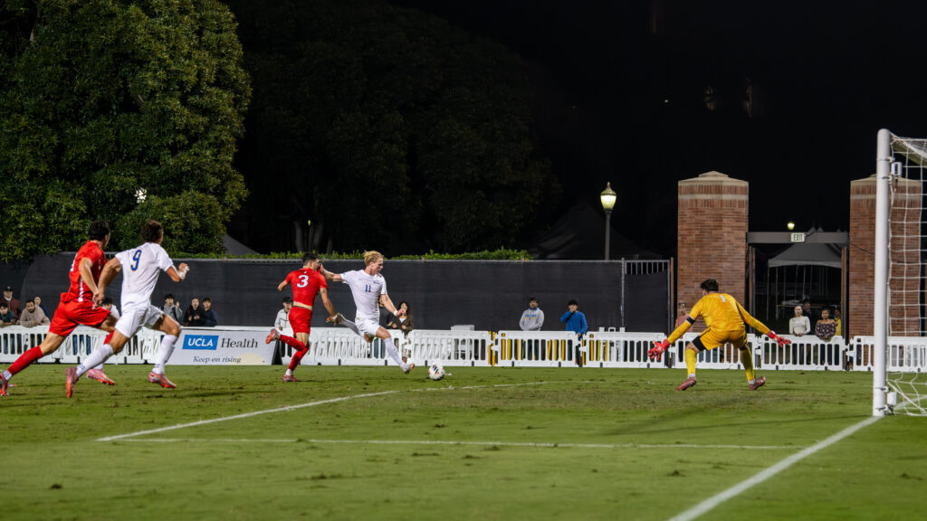 Player #11 Oliver Roche attacks with a strong kick, making the first goal of the game.