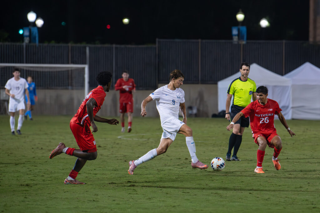 In a captivating moment, Sergi Solans demonstrates his exceptional speed in handling the ball against Rutgers' defenders.