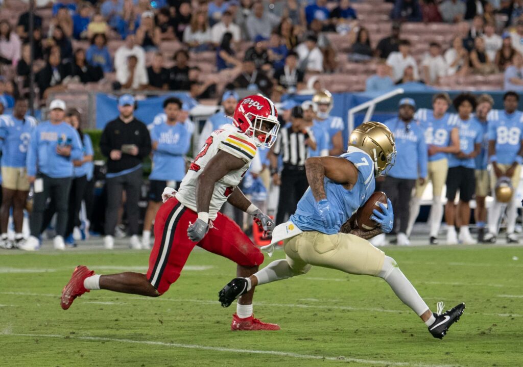 Mikey Matthews carries the ball while being pursued by Carlton Smith . Photographed by Aamani Maddukuri/BruinLife.