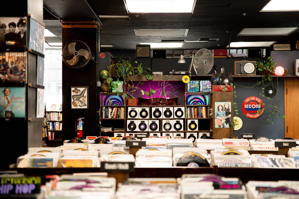 Rows upon rows of vinyl records occupy half of the first floor, with greenery scattered throughout. Vinyls have had a recent resurgence among people of all ages, and something is to be said of the appeal of analog forms of media — books and records alike. Photographed by Julia Gu/BruinLife.