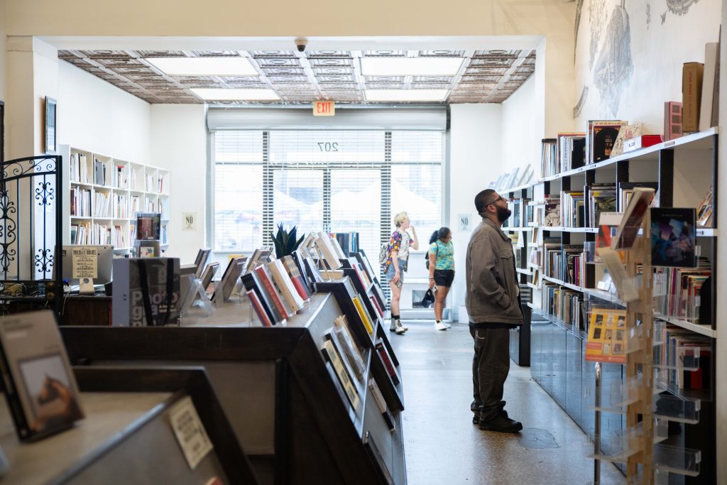 Customers browse the collection of books in the Arts and Rare Books Annex. Opposite them is a row of glass shelves that house some of the first and autographed editions of everything from sports to novels. Photographed by Julia Gu/BruinLife.