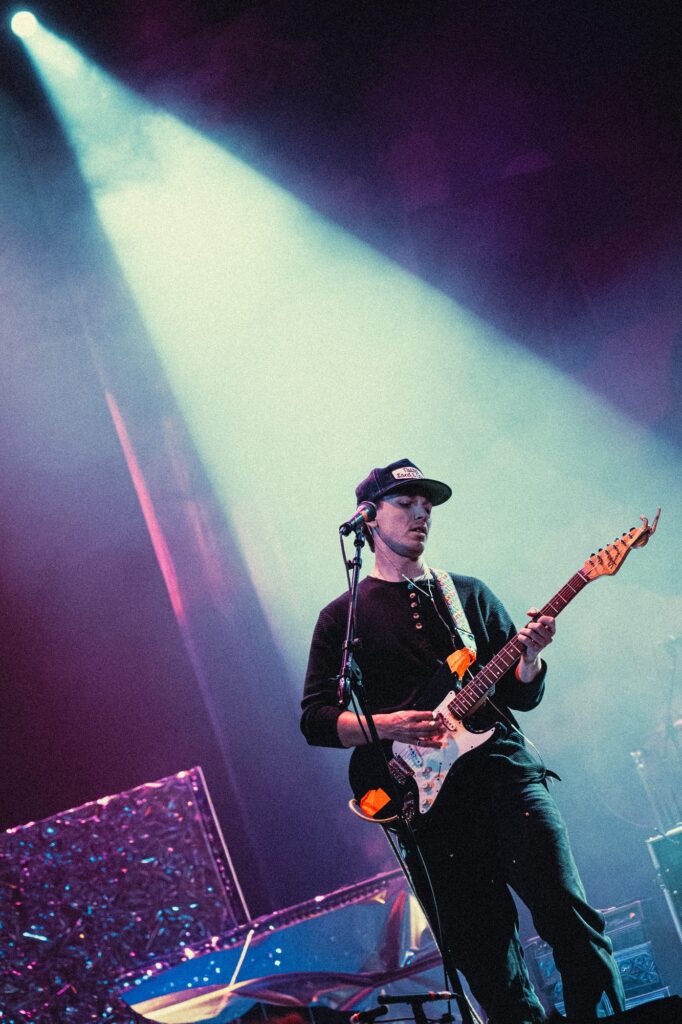 Oliver Martin looks down as he focuses on his guitar work during Krooked Kings’ opening set. Martin handles both lead vocals and guitar throughout the performance. Photographed by Amy Miranda/BruinLife.