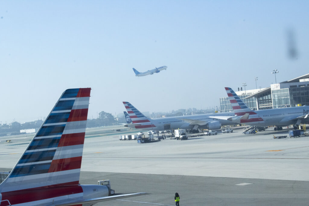 A United Airlines flight manages take off whilst countless other planes remain grounded in wake of the unforeseen government shutdown. I stared longingly from the bridge between LAX's American and International terminals -- desperately wishing I could be anywhere but here. Photographed by Gavin Meichelbock/BruinLife.