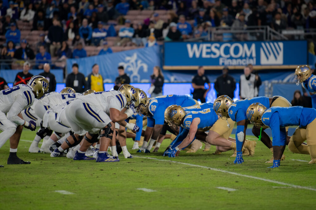 The Bruins and the Huskes prepare for the snap to start the play. The Bruins lost this match up 14-48 to the Huskies in Saturday night. Photographed by Regan Rhodes/BruinLife.