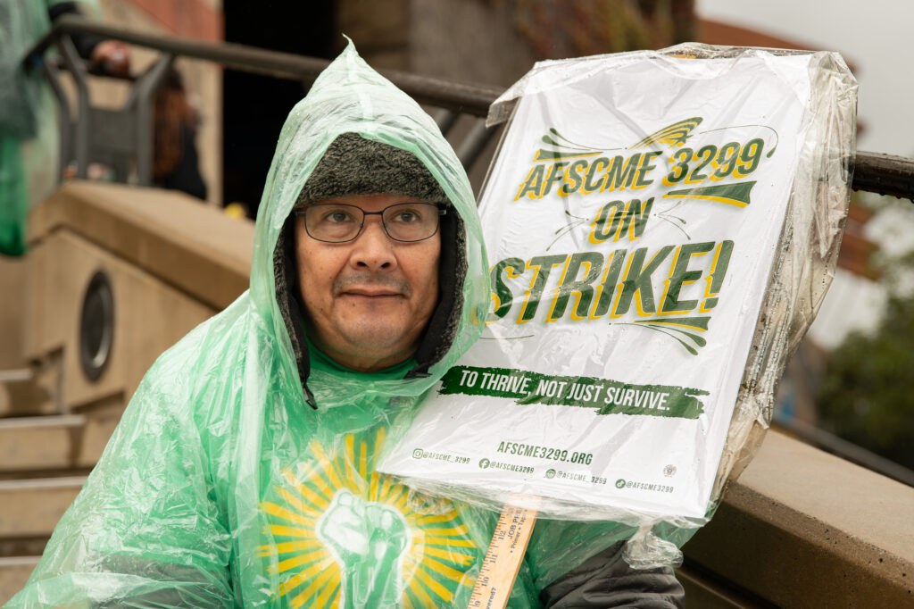 Frank Huaco, a local hospital worker, sits with a sign in the rain and protests as a part of the AFSCME 3299 strike. His presence and activism reflected the determination of workers advocating for fair working conditions. Photographed by Siena Hunt/BruinLife