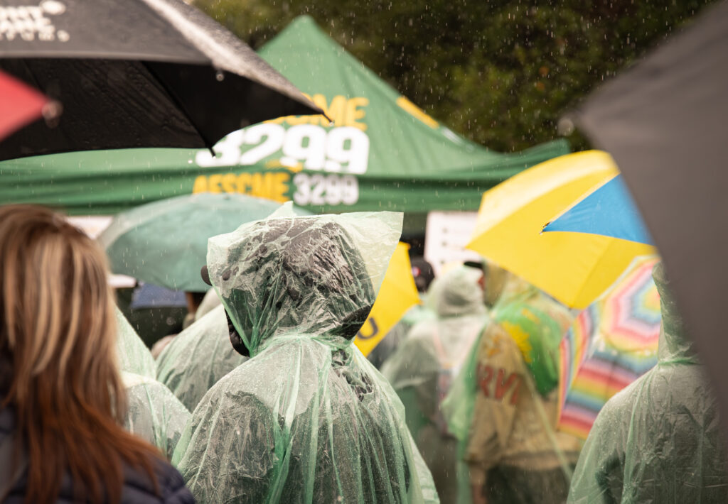 Strikers stand in the rain as they queue to clock out at the end of the strike. This moment captured the turnout despite the difficult weather conditions. Photographed by Siena Hunt/BruinLife