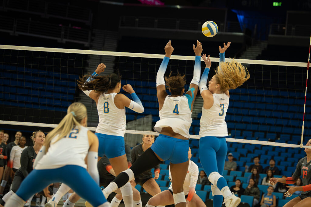 Kat Lutz (No. 22), Maggie Li (No. 8), Brooklyn Briscoe (No. 4) and Kate Duffey (No. 3), seen left to right, protect their teammates from Illinois' sudden spike. Photographed by Sapna Drew/BruinLife.