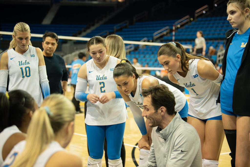 The team huddles around Nick Vogel, assistant coach, to hear in for instructions in between sets. Photographed by Sapna Drew/BruinLife.