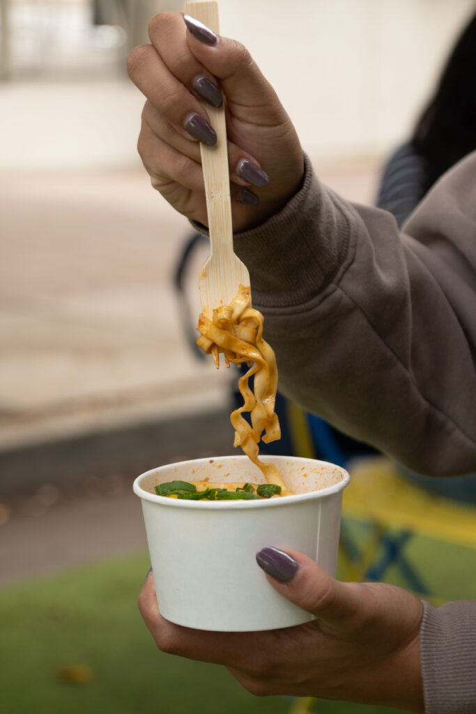 A student eat's Momofuku's Sweet and Spicy noodles, along with soy egg. Photographed by Aamani Maddukuri/BruinLife.